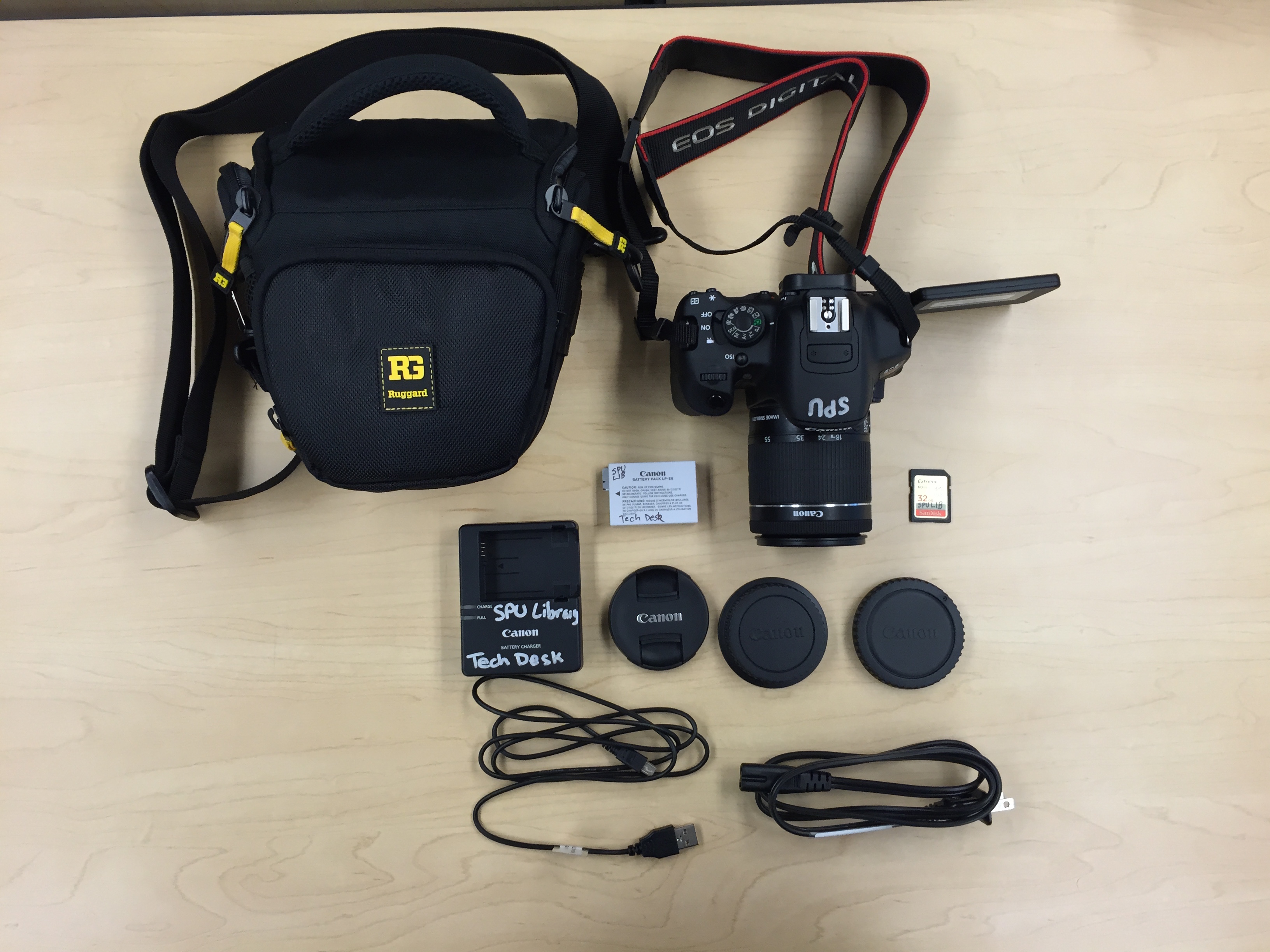 Canon EOS Rebel T5i Camera with shoulder strap, lens, lens cap, 2 lens storage caps, battery charger, battery power cable, battery pack, USB cable, Hunter case, SD card