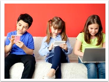 one boy and two girls sitting on a couch with a smartphone, tablet, and laptop.